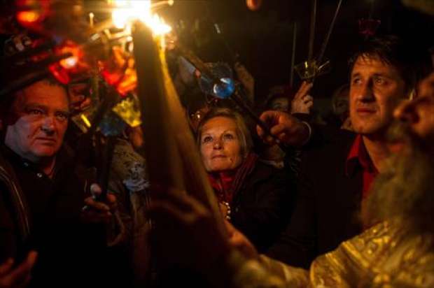 بالصور| المسيحيون يضيئون الشموع بالنار المقدسة القادمة من القدس في مقدونيا
