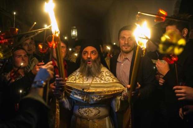 بالصور| المسيحيون يضيئون الشموع بالنار المقدسة القادمة من القدس في مقدونيا